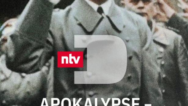 Adolf Hitler bei einer Parade mit erhobenem Arm.