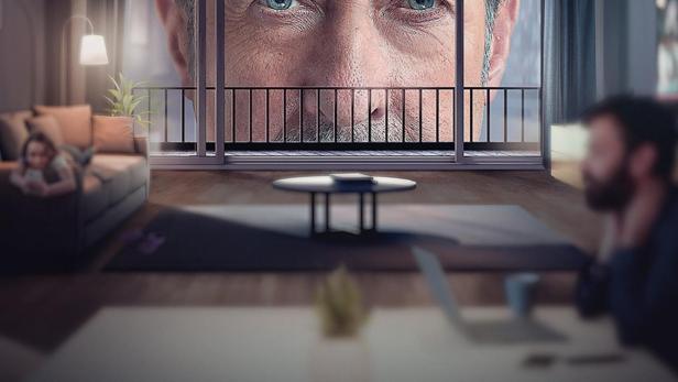 Das Filmplakat für „El Encargado“ zeigt ein riesiges Gesicht, das über eine Wohnung wacht.