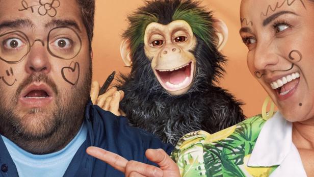 Ein Mann und eine Frau mit aufgemalten Gesichtern posieren mit der Disney-Puppe „Chueco“.