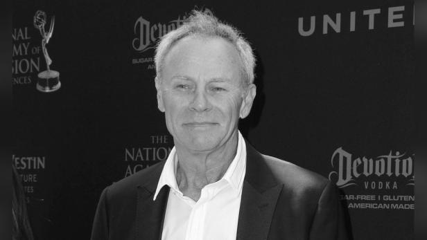 Schwarzweißporträt von Tristan Rogers vor einem schwarzen Hintergrund.