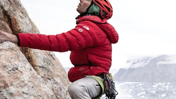 Alex Honnold klettert in arktischer Umgebung einen Felsen hoch.
