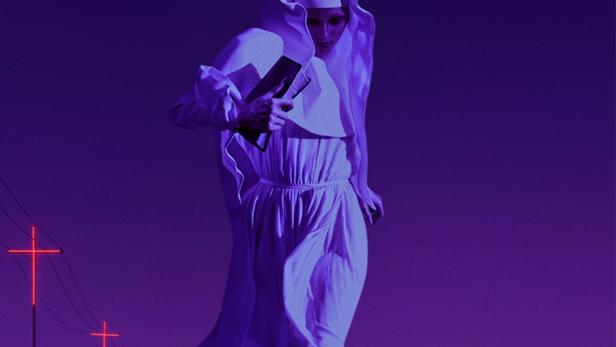 Eine Nonne geht eine dunkle Straße entlang, im Hintergrund leuchtende Kreuze.