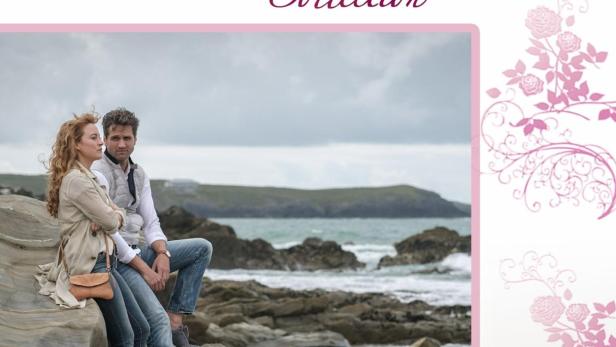 Ein Paar sitzt am Strand auf einem Felsen, im Hintergrund das Meer.