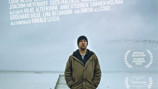 Das Filmplakat zu „Sörensen fängt Feuer“ zeigt einen Mann mit Hund auf einem Steg am Wasser.