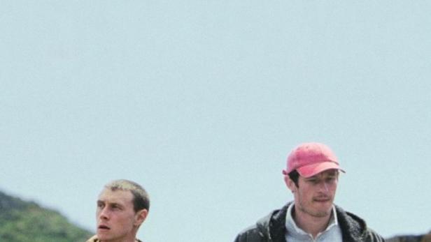 Zwei junge Männer gehen im Freien spazieren.