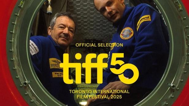 Zwei Männer in blauen Overalls schauen aus einer roten Kapsel, die für das Toronto International Film Festival 2025 ausgewählt wurde.
