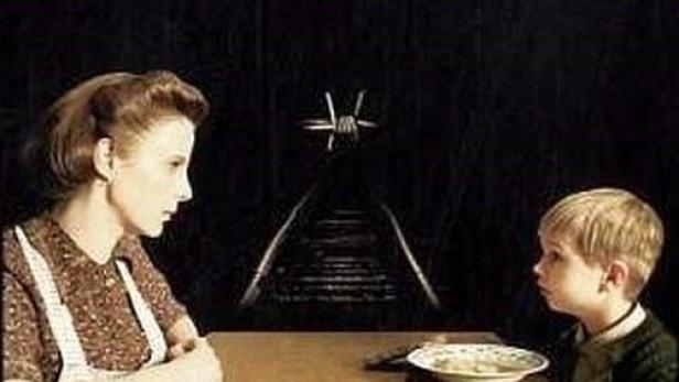 Das Filmplakat für „Spielzeugland“ zeigt eine Frau und einen Jungen an einem Tisch vor Bahngleisen.