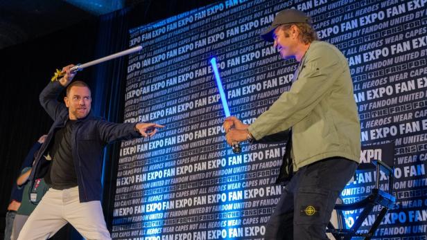 Star Wars-Stars McGregor und Christensen bieten bei Fan Expo auf Bühne Lichtschwertkampf.