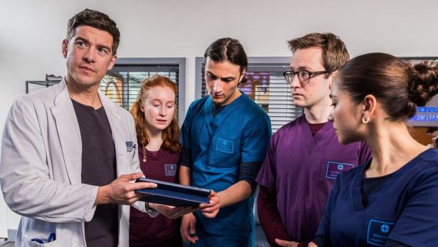 „Die jungen Ärzte“ aus gleichnamiger Serie zu einer Besprechung versammelt.
