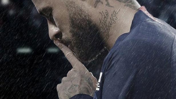 Neymar, mit blond gefärbten Haaren, hält den Finger an die Lippen.