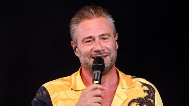 Pop-Star Sasha mit Mikro in der Hand.