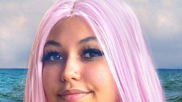 Das National Geographic-Plakat für „Haiangriff: Die Paige-Winter-Story“ zeigt eine junge Frau mit pinkfarbenem Haar vor einem Ozean.