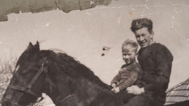 Ein junger Dr. Pol reitet mit einem Kind auf einem Pferd.