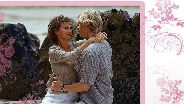 Ein Paar umarmt sich am Strand; Cover des Rosamunde Pilcher Films „Blüte des Lebens“.
