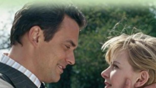 Ein Mann und eine Frau schauen sich liebevoll an, Titelbild von „Rosamunde Pilcher - Wege der Liebe“.