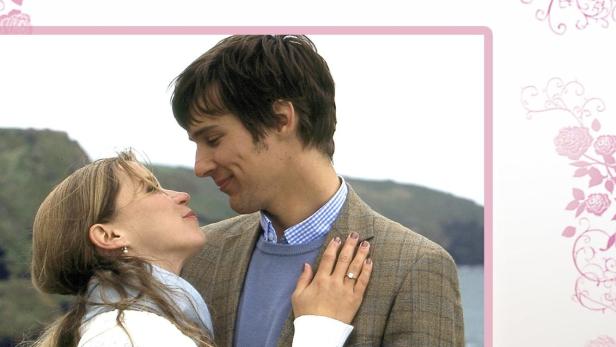 Ein Paar umarmt sich vor der Küste von Cornwall; Filmposter „Der Himmel über Cornwall“.