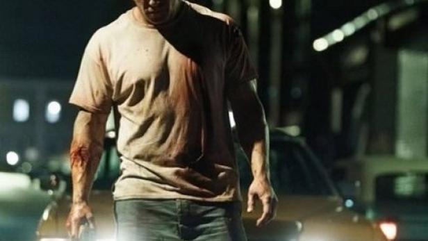 Ein blutverschmierter Mann steht vor einem Auto; Filmposter für „Motor City“.