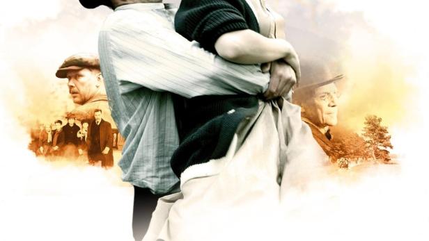 Ein Mann und eine Frau umarmen sich lachend auf dem Filmplakat zu „Maria Larssons ewige Augenblicke“.