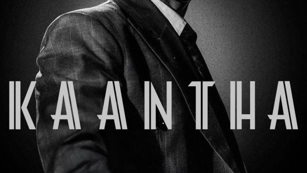 Ein Schwarzweißporträt eines Mannes im Anzug, möglicherweise eine Filmszene aus „Kaantha“.