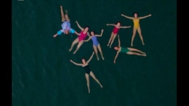 Eine Luftaufnahme von mehreren Frauen, die im Wasser treiben, möglicherweise eine Szene aus dem Film „Vainilla“ von Mayra Hermosillo.