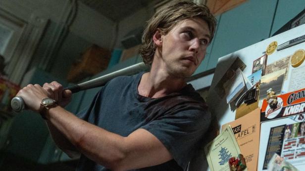 Austin Butler in „Caught Stealing“ mit hinter dem Kopf erhobenem Baseballschläger vor einem Kühlschrank.