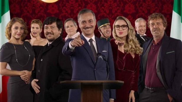 Das Filmplakat für „Natale a 5 Stelle“ zeigt eine Gruppe von Schauspielern vor italienischen Flaggen.