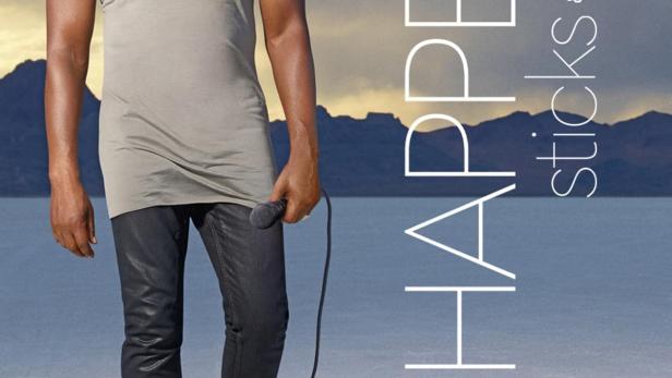 Dave Chappelle steht mit einem Mikrofon in der Hand in einer Wüstenlandschaft.