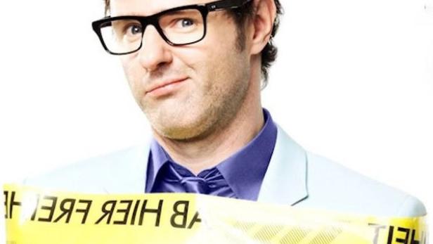 Vince Ebert, mit gelbem Band umwickelt, auf dem „Freiheit“ steht.