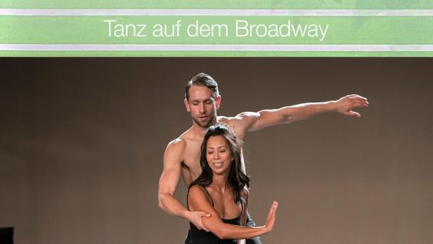Ein Mann und eine Frau tanzen auf einer Bühne vor dem Cover des Buches „Tanz auf dem Broadway“ von Katie Fforde.