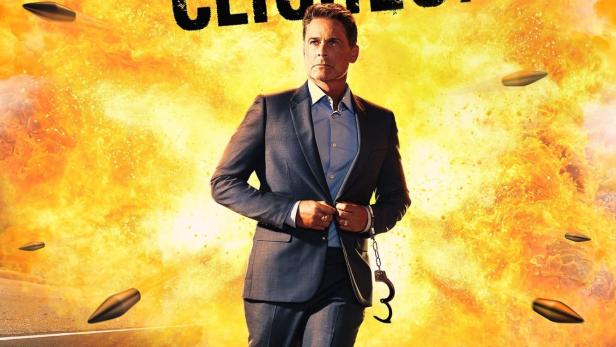 Ein Mann in einem Anzug geht vor einer Explosion auf einer Straße entlang, der Titel lautet „Attack of the Hollywood Clichés!“.