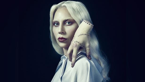 Plakatmotiv zeigt Lady Gaga in ihrer „Wednesday“-Serienrolle mit dem eiskalten Händchen auf ihrer Schulter.