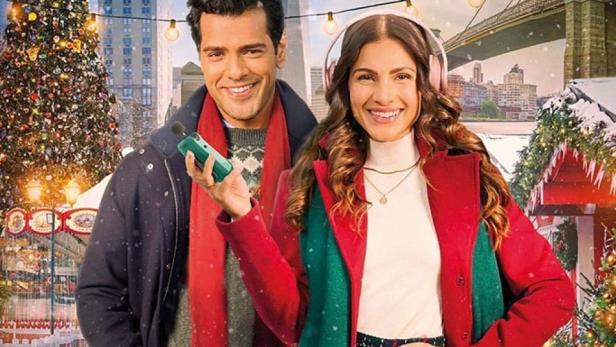Das Filmplakat für „Verführerische Weihnachten“ zeigt Fuad Ahmed und Kalinka Petrie vor einer weihnachtlichen New Yorker Kulisse.