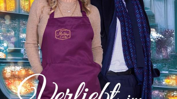 Das Filmplakat für „Verliebt im Winter“ zeigt eine Frau mit Schürze und einen Mann mit Schal vor einem Laden.