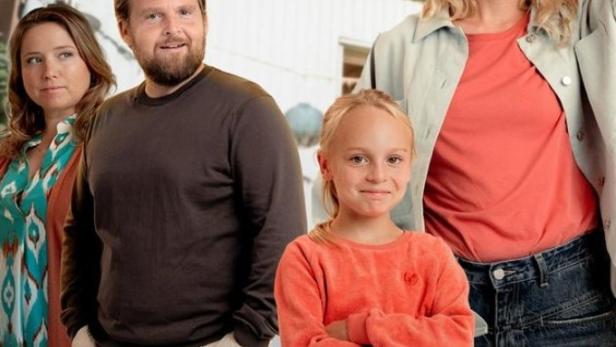 Eine Familie steht vor einem hellen Haus, im Vordergrund der Titel „Wer füttert den Hasen?“.