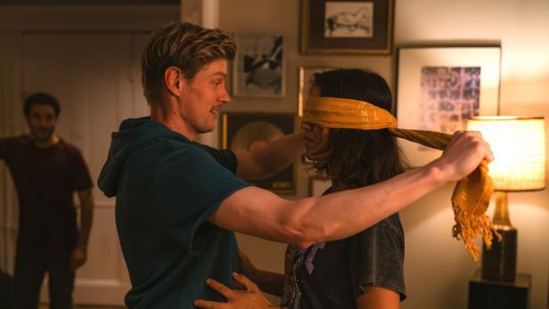 Mann verbindet Frau mit einem Tuch die Augen.