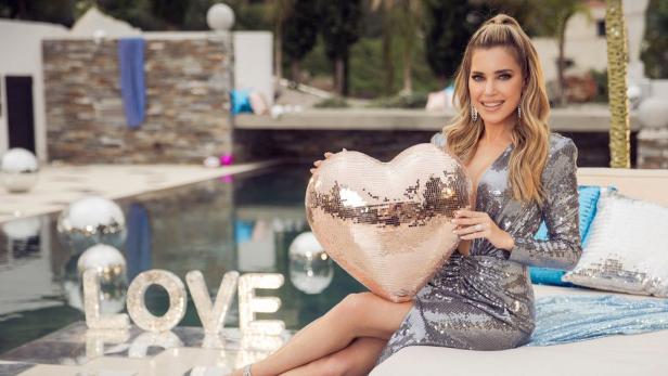 Moderatorin Sylvie Meis hält ein schimmerndes Herz in die Höhe.