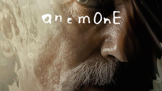 Das Gesicht eines Mannes ist durch eine verschwommene Oberfläche mit dem Schriftzug „anemOne“ zu sehen.