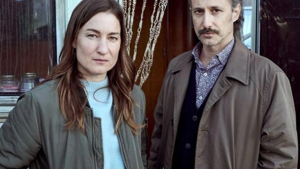 Eine Frau und ein Mann stehen vor einem Wohnwagen.