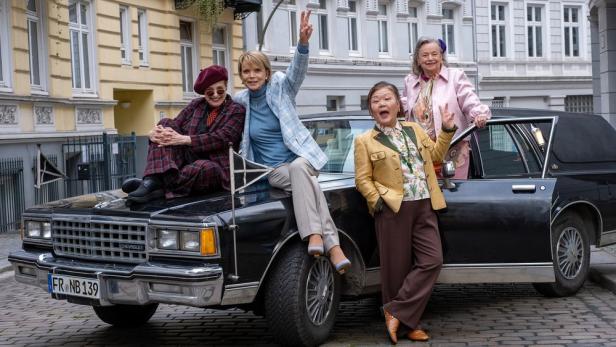 Katharina Thalbach, Uschi Glas, Soogi Kang und Ursula Werner posieren auf und neben einem Auto.