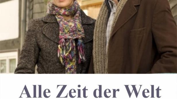 Ein Mann und eine Frau stehen vor einem Haus mit einer Uhr im Film „Alle Zeit der Welt“.