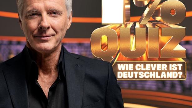 Kai Pflaume vor dem Logo der Quizsendung „Das 1% Quiz – Wie clever ist Deutschland?“.