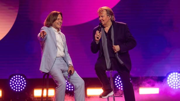 Jürgen Drews und Howard Carpendale sitzen einander auf der Showbühne gegenüber.