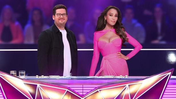 Chris Tall und Verona Pooth stehen vor einem Pult in einem TV-Studio