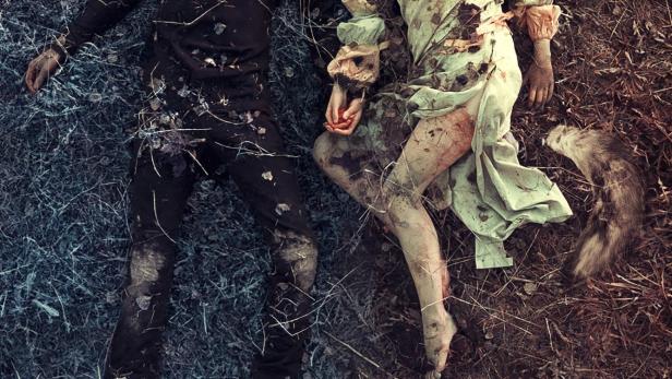 Ein Mann und eine Frau liegen leblos im Gras, möglicherweise eine Filmszene.