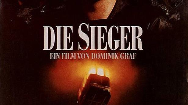 Das Filmplakat für „Die Sieger“ von Dominik Graf zeigt mehrere Männer und einen brennenden Bus.
