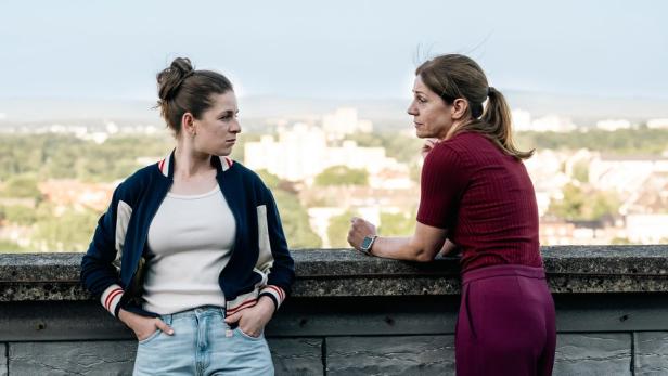 Zwei FRauen sprechen miteinander auf dem Dach eines Krankenhauses