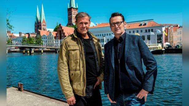 Zwei Männer stehen vor einem Kanal in einer norddeutschen Stadt