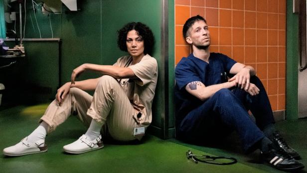 Haley Louise Jones und Slavko Popadić sitzen im Spital auf dem Boden