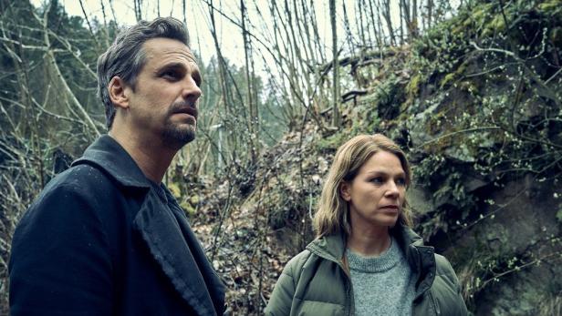 Mann und Frau stehen in einer Waldsenke