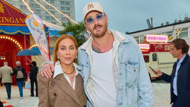 Mann und Frau aneinandergelehnt vor einem Zirkuszelt 